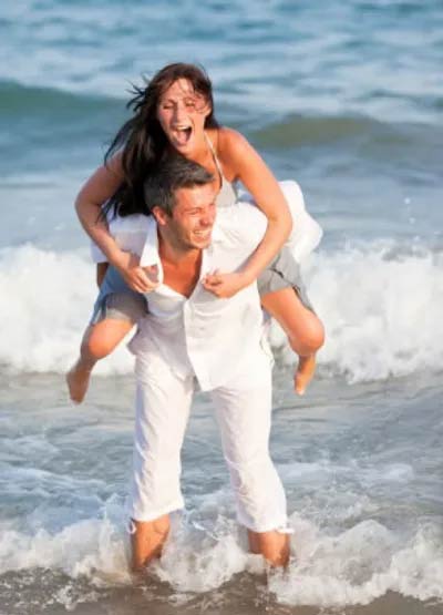 Woman on Man's Back on Beach